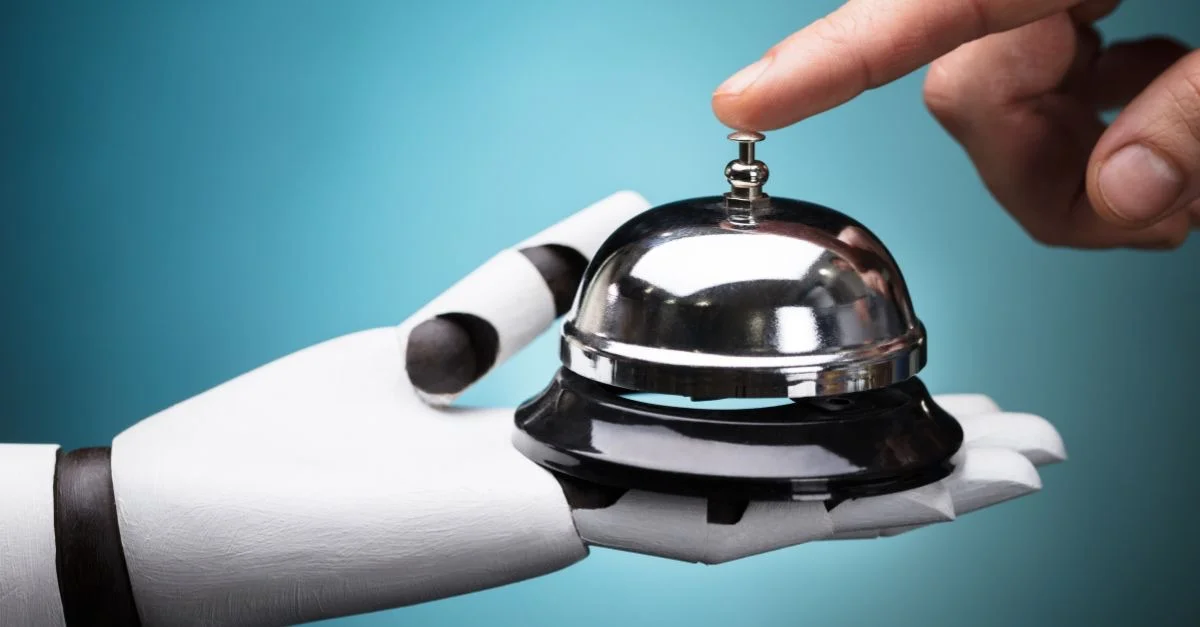 Main de robot qui tient une sonnette de service, touchée par un doigt humain