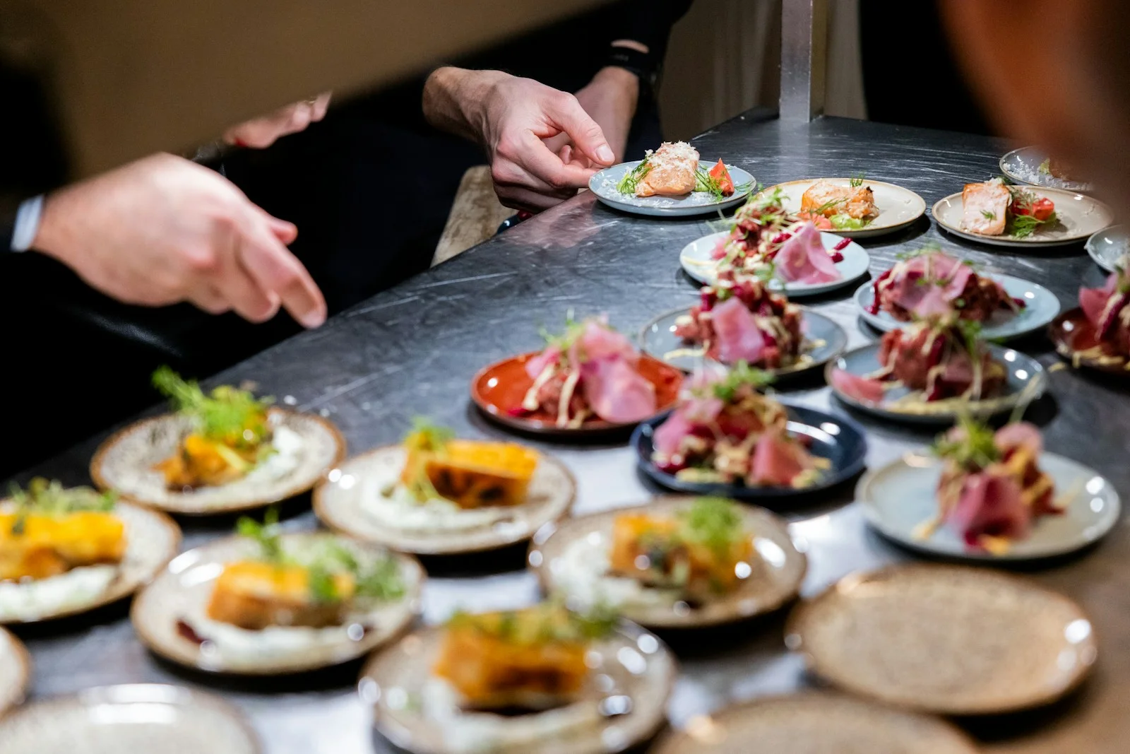 Assiettes dressées en série sur le passe d’une cuisine de traiteur